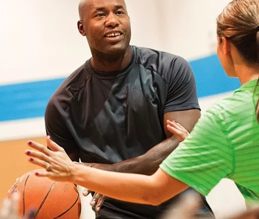 adults playing basketball